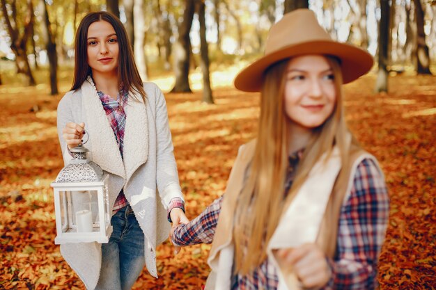 Le belle ragazze si divertono in un parco in autunno