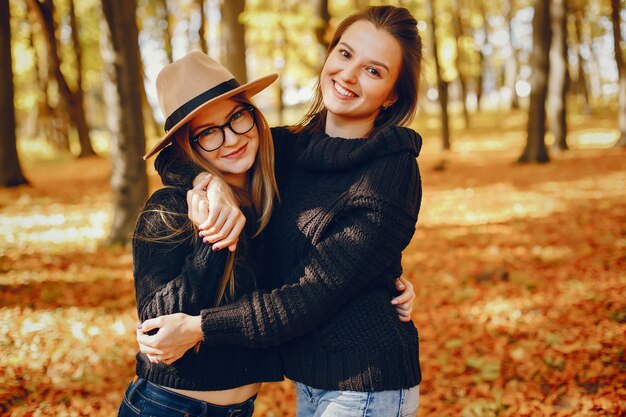 Le belle ragazze si divertono in un parco in autunno