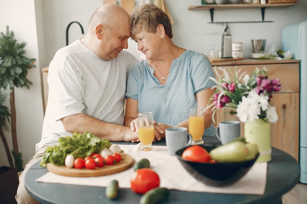 Le belle vecchie coppie preparano l'alimento in una cucina