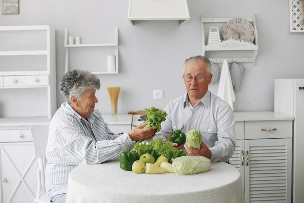 Le belle vecchie coppie preparano l'alimento in una cucina