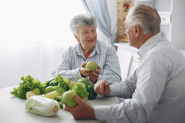 Le belle vecchie coppie preparano l'alimento in una cucina