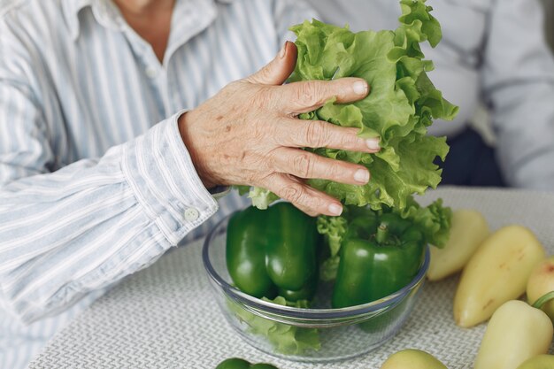 Le belle vecchie coppie preparano l'alimento in una cucina