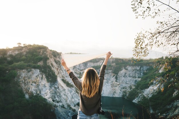 Le braccia della donna si sono alzate e tenendo la bandiera sulla montagna