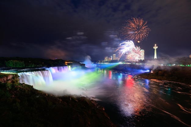 Le cascate del Niagara illuminate di notte da luci colorate con fuochi d'artificio