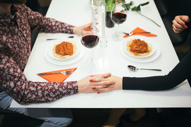 Foto gratuito le coppie del raccolto che si tengono per mano sul tavolo