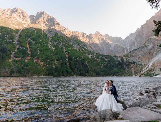 Le coppie di nozze stanno baciando vicino al lago nelle montagne di autunno, Morskie Oko