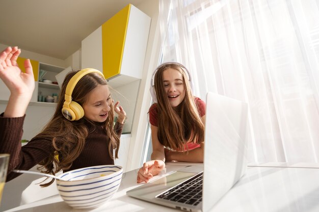 Le cugine trascorrono del tempo insieme a casa con il laptop