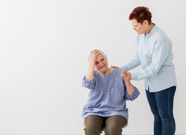 Le donne anziane si prendono cura l'una dell'altra con spazio di copia