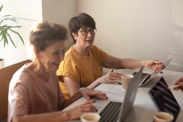 Le donne anziane trascorrono del tempo insieme e lavorano sui loro laptop