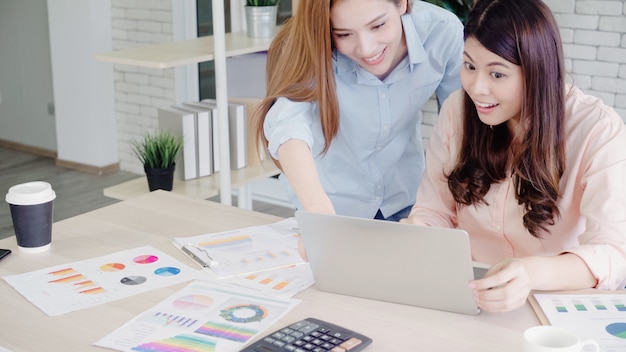 Le donne asiatiche di affari che ritengono le armi felici hanno sollevato la celebrazione