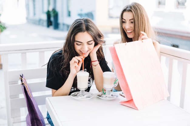 Le donne che beve milkshakes nel caffè