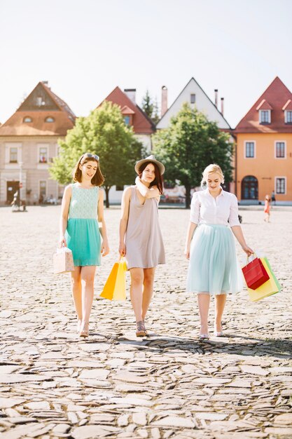 Le donne che camminano con gli acquisti sulla strada