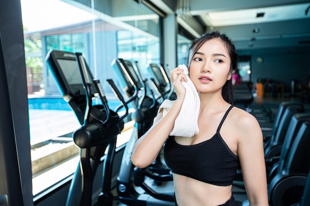 Le donne dopo l'allenamento, pulire il viso con un panno bianco in palestra.