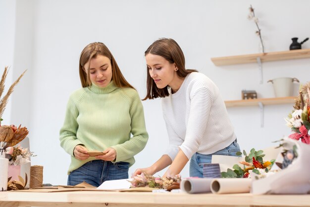 Le donne nella loro lettura del negozio di fiori