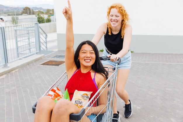 Le donne si divertono dopo lo shopping ridendo e guardando la fotocamera