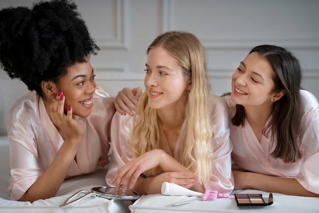 Le donne sorridenti che mettono su compongono il tiro medio