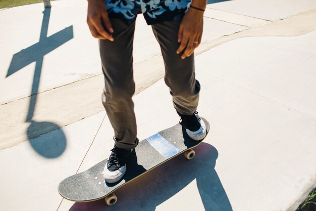 Le gambe del ragazzo moderno durante lo skateboard