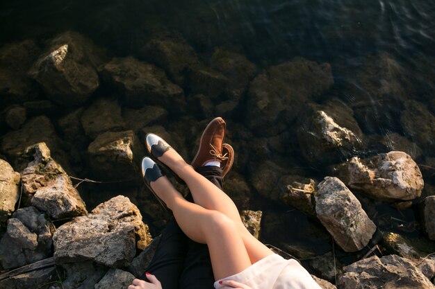 Le gambe di una coppia sulle rocce in riva al mare