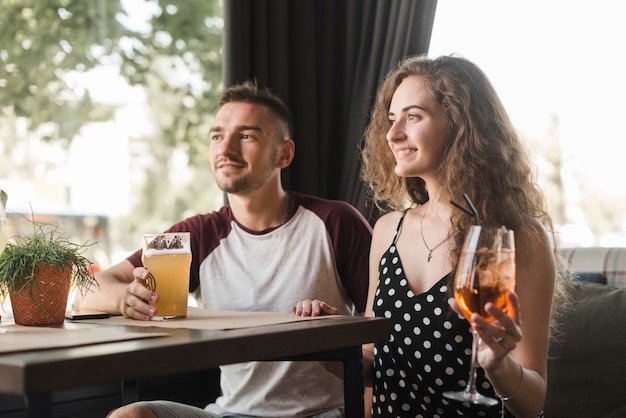 Le giovani coppie che si siedono nella holding del ristorante beve