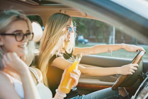 Le giovani donne in macchina sorridono