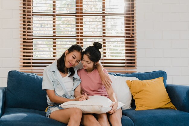 Le giovani donne lesbiche asiatiche lbbtq abbracciano e baciano a casa