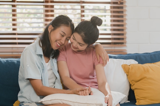 Le giovani donne lesbiche asiatiche lbbtq abbracciano e baciano a casa