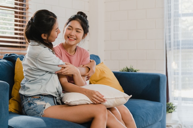 Le giovani donne lesbiche asiatiche lbbtq abbracciano e baciano a casa