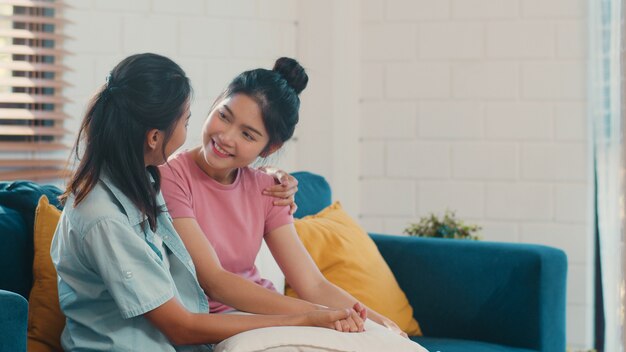 Le giovani donne lesbiche asiatiche lbbtq abbracciano e baciano a casa