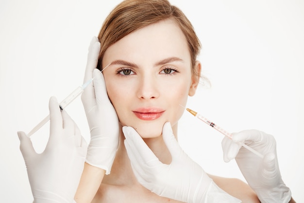 Le mani dei cosmetologi che fanno iniezioni di botox medico alla bella bionda. Sollevamento della pelle. Trattamento facciale. Bellezza e spa.