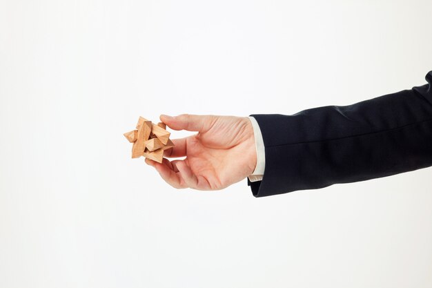 Le mani dell'uomo che tengono puzzle di legno.