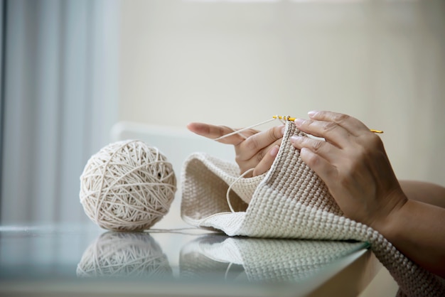 Le mani della donna che fanno il lavoro a maglia domestico