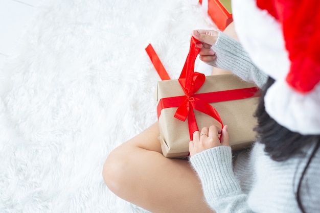 le mani della donna sta aprendo il regalo di natale