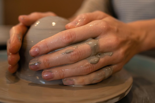 Le mani di ceramica del primo piano scolpiscono i piatti bali