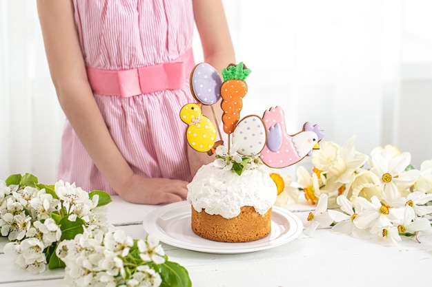 Le mani di una bambina che decora una torta festiva. Il concetto di preparazione per le vacanze di Pasqua.