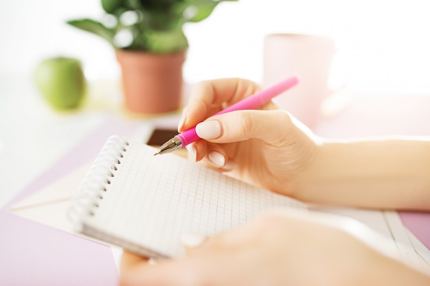 Le mani femminili che tengono la penna