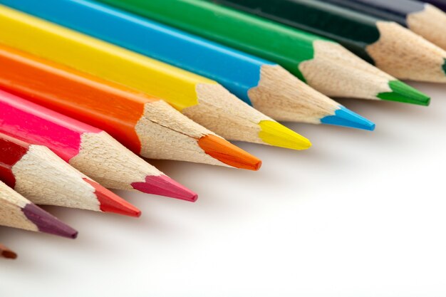 Le matite multicolori per il disegno hanno allineato sullo scrittorio bianco