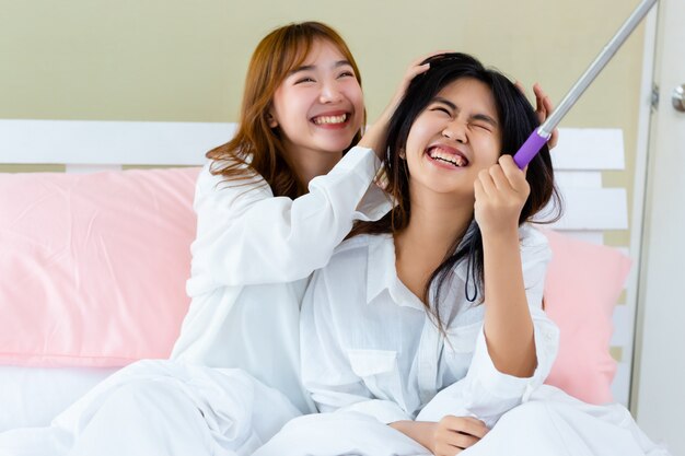 Le migliori amiche adolescenti allegre con selfie sul letto