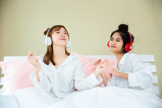 Le migliori amiche allegre ascoltando la canzone in camera da letto