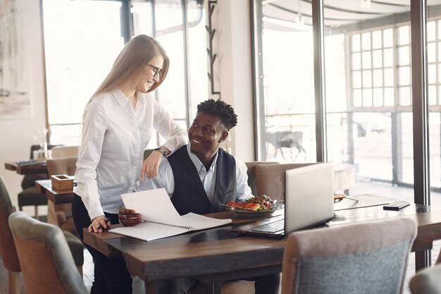 Le persone alla moda lavorano in un ufficio e usano il laptop