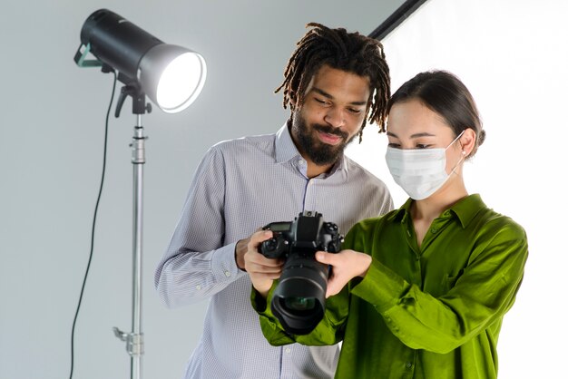 Le persone con fotocamera e maschera medica