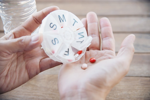 Le persone preparano quotidianamente una compressa di medicina nel portapillole