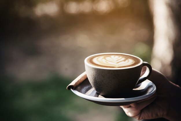 Le persone servono una bella e fresca tazza di caffè al mattino