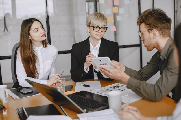 Le persone stanno lavorando al progetto. Uomo e donna in giacca e cravatta seduti al tavolo. Gli uomini d'affari usano un laptop.