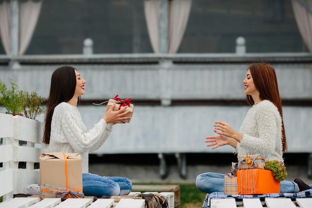 Le ragazze gettando un regalo marrone tra di loro