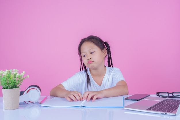 Le ragazze scrivono libri su uno sfondo rosa.