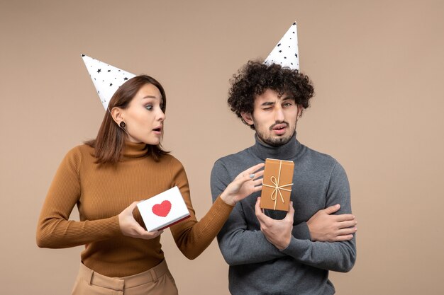 Le riprese di Capodanno con la giovane coppia scioccata pazza emotiva indossano la ragazza curiosa del cappello del nuovo anno con il cuore