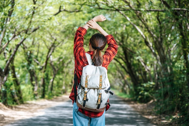 Le turisti donne portano uno zaino e stanno in piedi sulla strada.