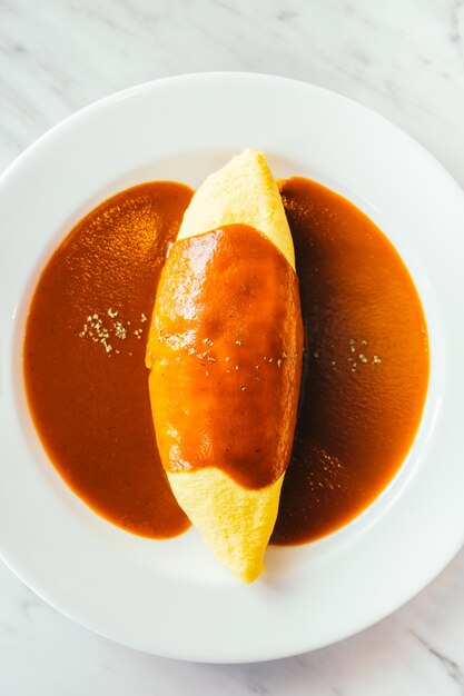 Le uova di omelette avvolgono il riso con la salsa