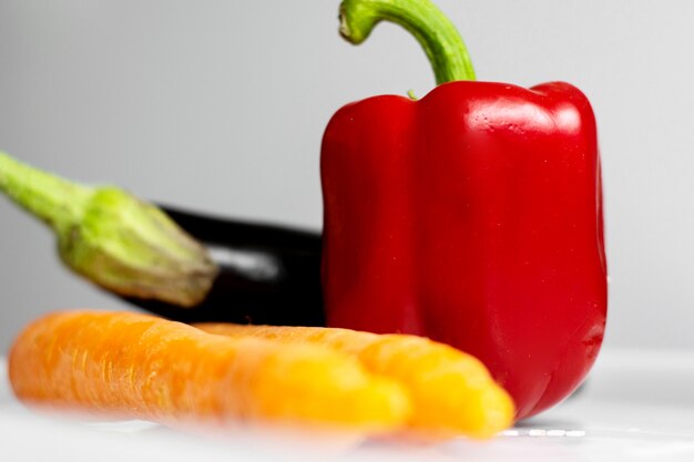 Le verdure fresche della vitamina matura hanno arricchito le verdure variopinte sul pavimento bianco