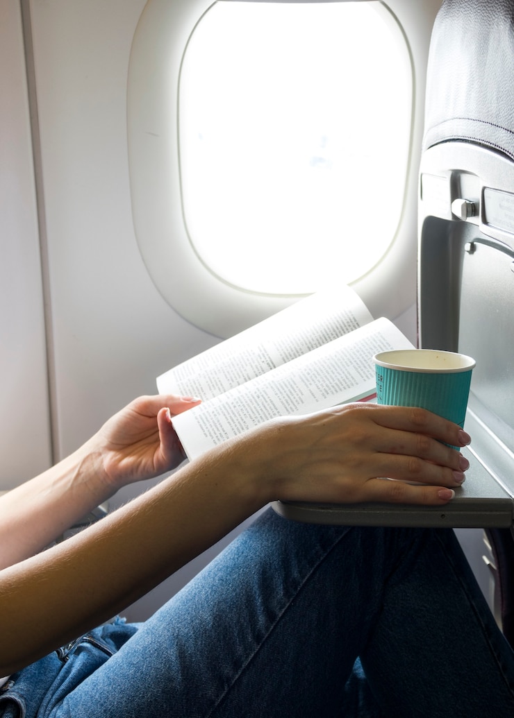 Foto gratuito leggere un libro e tenere una tazza